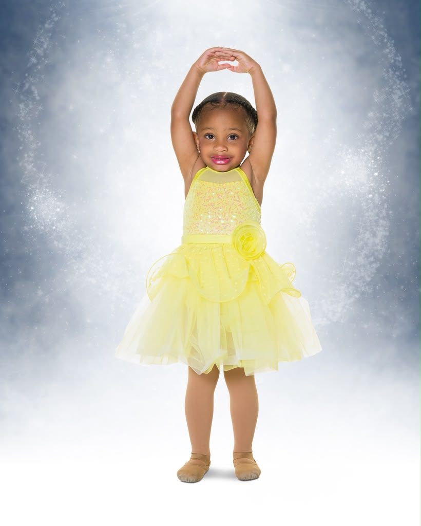 Kreelyn in a yellow tulle ballet costume with arms overhead