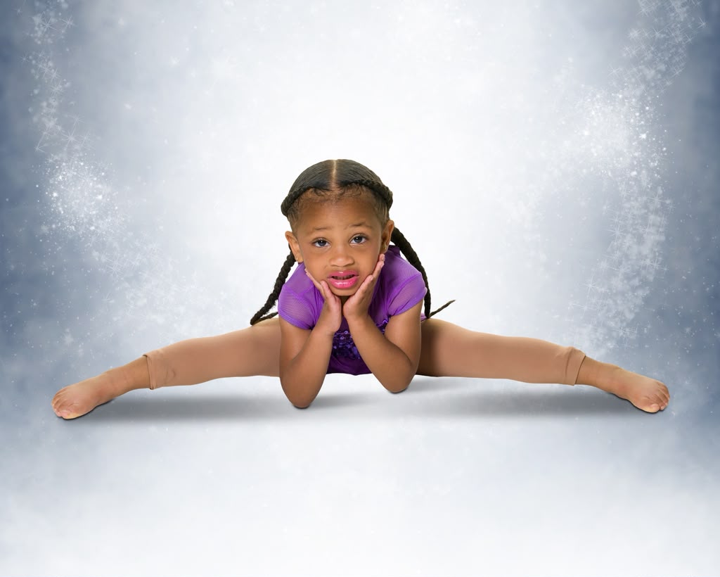 Kreelyn holding a full center split on a sparkling studio backdrop