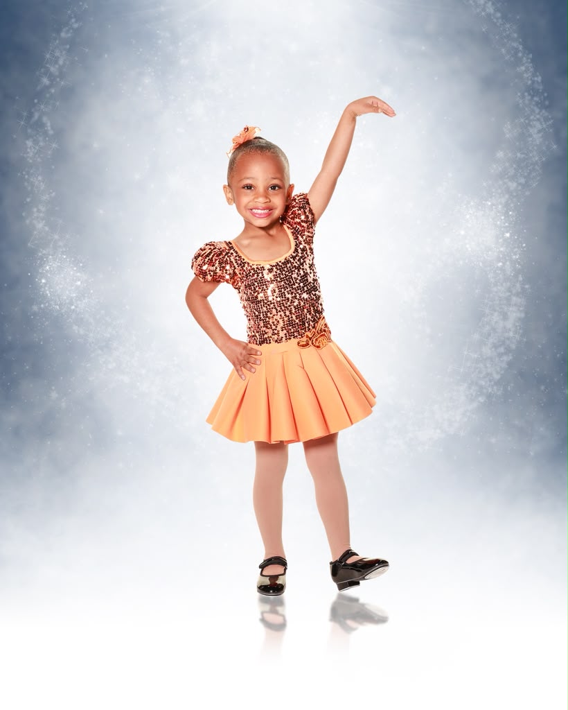 Kreelyn posing in an orange sequined tap costume